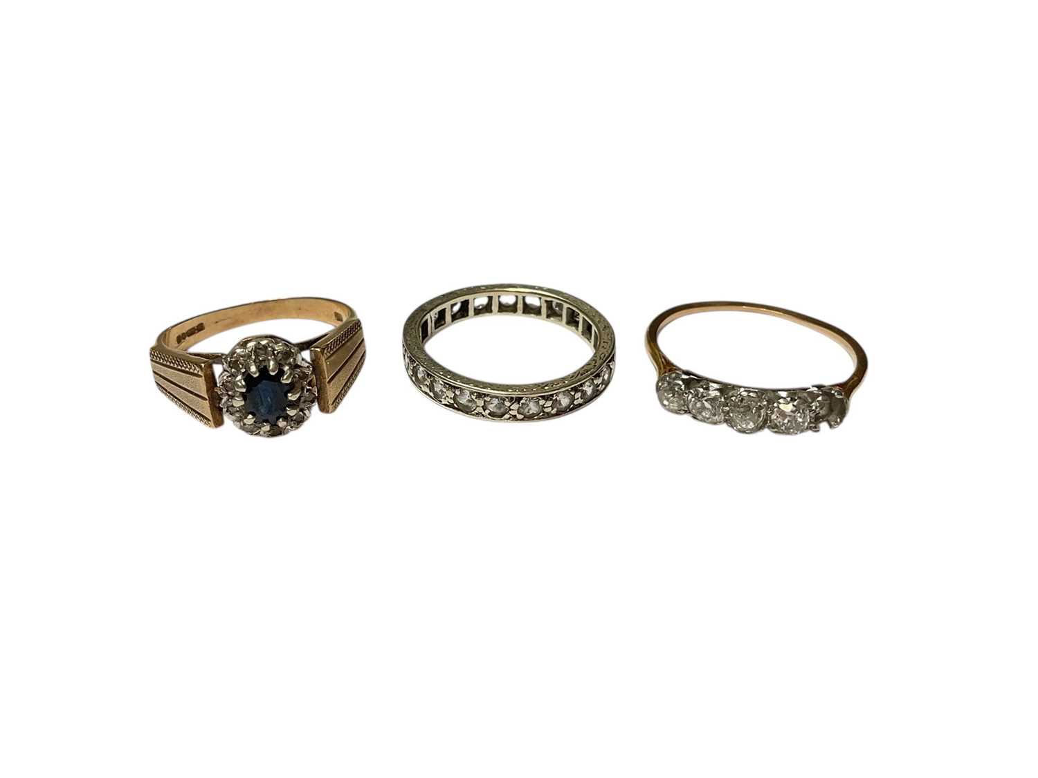 Lot 220 - Diamond ring with four old cut diamonds (one missing) in yellow metal setting, 9ct gold sapphire and diamond cluster ring and a white stone eternity ring in 9ct white gold setting (3)