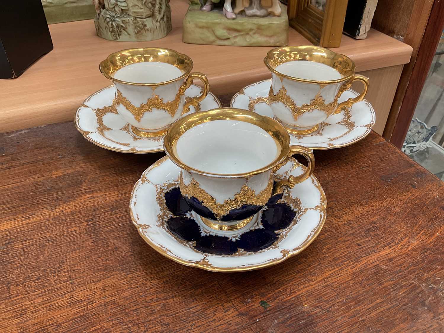 Lot 129 - Three Meissen gilt moulded breakfast cups and saucers, the saucers 15.75cm diameter