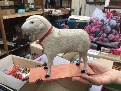 Lot 1820 - Two early Putz sheep with painted faces, green glass eyes, wool plush and wooden stick legs, 15cms and 18cms approximately . Plus similar dog with amber glass eyes 15cms.