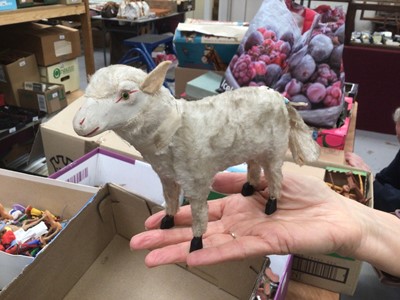 Lot 1820 - Two early Putz sheep with painted faces, green glass eyes, wool plush and wooden stick legs, 15cms and 18cms approximately . Plus similar dog with amber glass eyes 15cms.