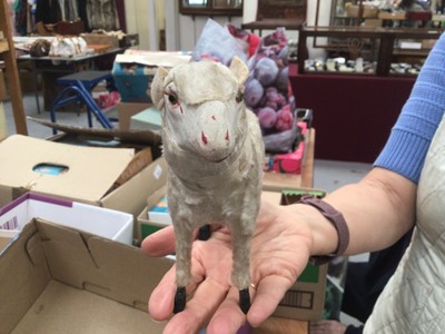 Lot 1820 - Two early Putz sheep with painted faces, green glass eyes, wool plush and wooden stick legs, 15cms and 18cms approximately . Plus similar dog with amber glass eyes 15cms.