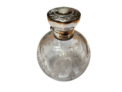 Lot 23 - Edwardian silver mounted glass scent bottle of globular form with engraved floral and ribbon decoration (Birmingham 1906), together with another antique silver mounted glass scent bottle and a s...