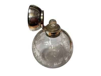 Lot 23 - Edwardian silver mounted glass scent bottle of globular form with engraved floral and ribbon decoration (Birmingham 1906), together with another antique silver mounted glass scent bottle and a s...
