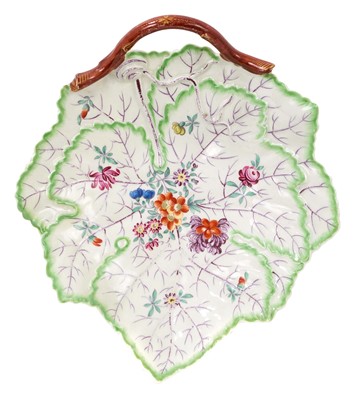 Lot 207 - A Worcester leaf dish, circa 1770, formed as two overlapping leaves, with a curled stalk handle, painted with flowers and purple veins, the edges of the leaves coloured in green, 23cm across