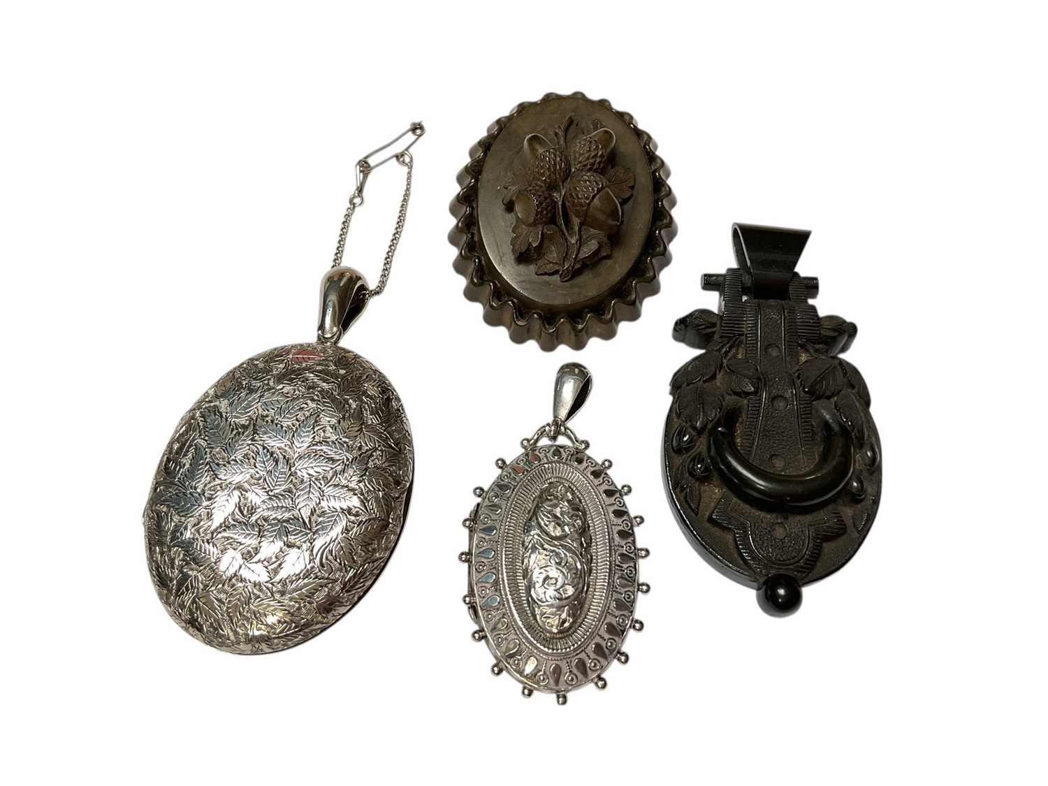 Lot 164 - Two Victorian silver oval lockets with engraved decoration, a Victorian gutta-percha pendant and brooch (4)
