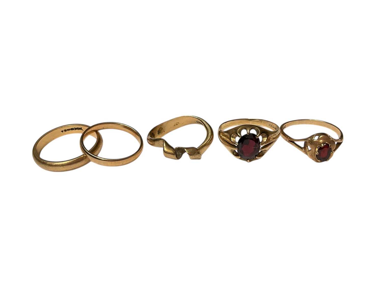Lot 62 - Five 9ct gold rings to include two wedding bands, twisted band ring and two garnet set rings