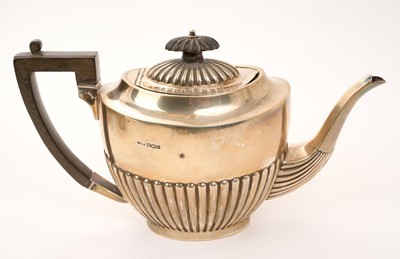 Lot 475 - Edwardian silver tea pot of half fluted form, with hinged domed cover and angular ebony handle