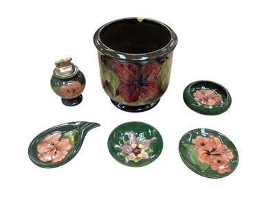 Lot 1019 - Five pieces of Moorcroft pottery on green ground to include two bowls, ashtray, table lighter and a dish, together with a Moorcroft jardiniere on brown ground (6)