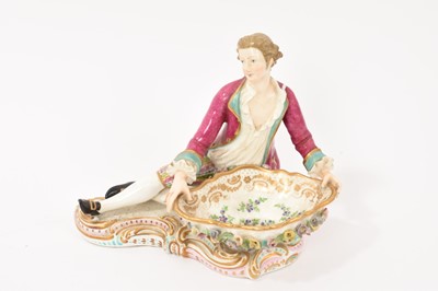 Lot 316 - A Derby porcelain seated figure holding a bowl, forming a sweetmeat dish. All standing on a shaped base. See attached Christies catalogue, lot 109