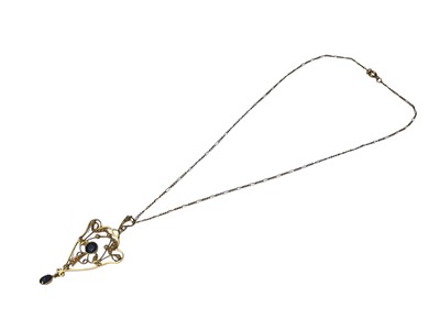 Lot 126 - Edwardian 15ct gold sapphire and seed pearl open work scroll pendant on a gold plated chain