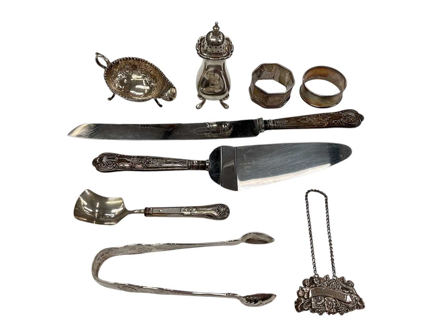 Lot 135 - Victorian silver kings pattern sugar tongs (London 1894), together with a George V silver pepperette (Birmingham 1923), silver napkin rings, cream jug and other items (various dates and makers)....