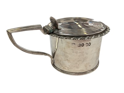 Lot 137 - Early Victorian silver mustard pot of drum form with gadrooned border, reeded angular handle and interior with blue glass liner, (London 1838), 5.1cm in overall height.