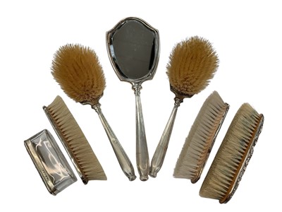 Lot 141 - George VI silver backed hand mirror with engine turned decoration, together with three matching silver backed brushes, (London 1947), two further silver backed brushes and a silver topped vanity...