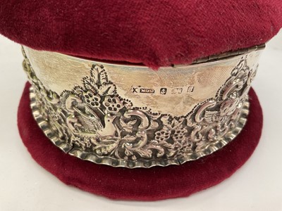 Lot 234 - Two Victorian silver mounted pin cushion jewellery boxes both with embossed scroll decoration, together with a smaller 1920s silver mounted pin cushion trinket box