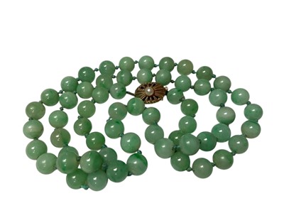 Lot 238 - Jade/ green hardstone polished spherical bead necklace with an oval 9ct gold clasp set with a single pearl, 54cm long