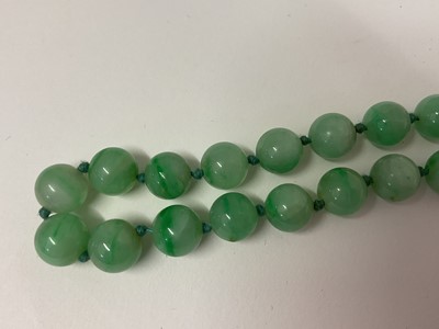 Lot 238 - Jade/ green hardstone polished spherical bead necklace with an oval 9ct gold clasp set with a single pearl, 54cm long