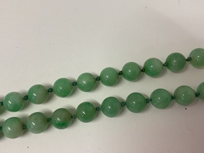 Lot 238 - Jade/ green hardstone polished spherical bead necklace with an oval 9ct gold clasp set with a single pearl, 54cm long