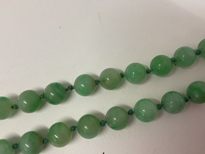 Lot 238 - Jade/ green hardstone polished spherical bead necklace with an oval 9ct gold clasp set with a single pearl, 54cm long