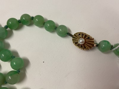 Lot 238 - Jade/ green hardstone polished spherical bead necklace with an oval 9ct gold clasp set with a single pearl, 54cm long