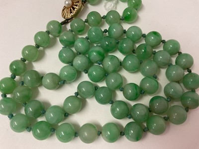 Lot 238 - Jade/ green hardstone polished spherical bead necklace with an oval 9ct gold clasp set with a single pearl, 54cm long