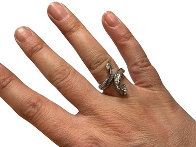 Lot 247 - Diamond cross over ring with baguette cut diamonds in a channel setting