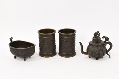 Lot 989 - Group of Chinese bronzes, including a pair of brush pots, each moulded with dragon relief, 12.5cm high, together with a boat shaped vessel and a teapot and cover. (4)