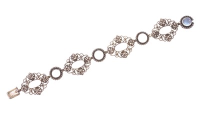 Lot 639 - Arts & Crafts silver moonstone and marcasite bracelet, probably by Sibyl Dunlop, with seven cabochon moonstones in silver setting with pierced panels and marcasite flowers, 17.5cm length, in...