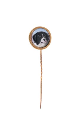 Lot 756 - A 19th century gold and enamel stick pin, the circular polychrome enamel plaque finely painted with a portrait of a dog, in gold mount with rope twist border, 20.3mm, on a gold pin, 75mm length....