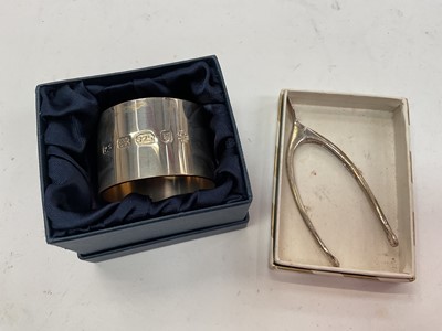 Lot 1061 - Contemporary silver napkin ring, boxed and a pair of silver wishbone sugar nips (2)