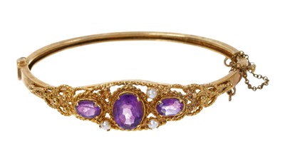 Lot 436 - Victorian style amethyst and gold bangle with three oval mixed-cut amethysts