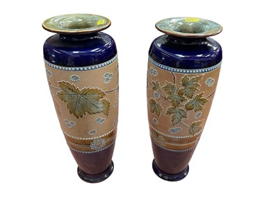 Lot 167 - Pair of Royal Doulton stoneware vases decorated with flowers and leaves.