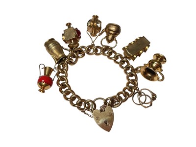 Lot 11 - 9ct gold curb link charm bracelet with padlock clasp and a collection of 9ct gold and yellow metal novelty charms