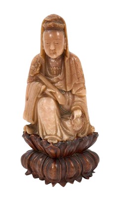 Lot 749 - A fine quality Chinese carved soapstone figure of Guanyin, probably Qianlong period, shown seated, wearing a robe and holding a Ruyi sceptre, traces of paint, old label to base, on a carved wood...