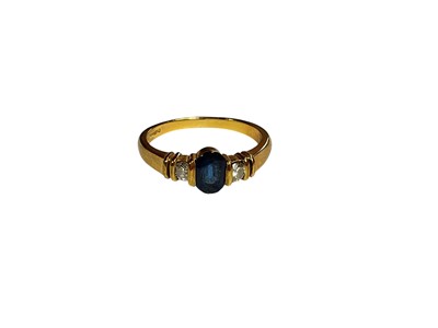 Lot 16 - Sapphire and diamond three stone ring with a central oval mixed cut blue sapphire flanked by two brillint cut diamonds in 18ct gold setting