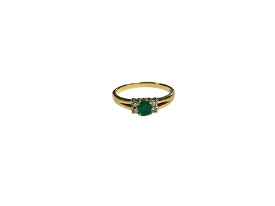 Lot 17 - Emerald and diamond ring with a central oval mixed cut emerald flanked by four brillint cut diamonds in claw setting with split shoulders on 18ct gold shank