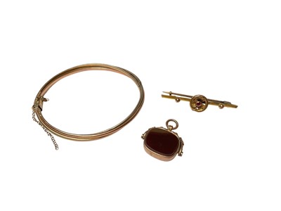 Lot 66 - 9ct three colour gold twisted bangle, 9ct gold mounted rotating hard stone fob and Edwardian 9ct gold bar brooch (3)