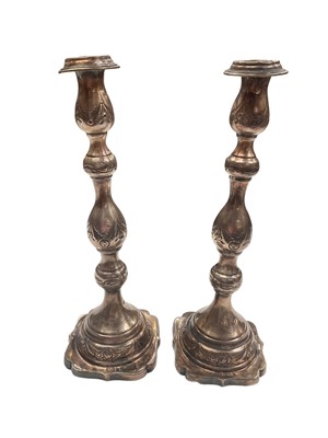 Lot 1003 - Pair of silver Shabbat candlesticks with embossed floral scroll decoration and engraved presentation inscription (London 1932)