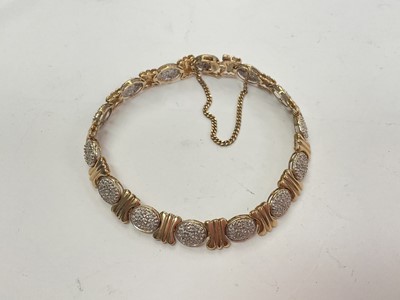 Lot 1011 - Gold and diamond bracelet with fourteen oval diamond clusters, estimated to weigh 0.50cts in total, interspaced with gold links