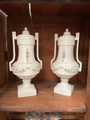 Lot 90 - Pair of antique bisque lidded urns with applied floral garlands