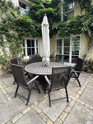 Lot 1278 - Teak circular garden table, eight matching chairs with covers and an umbrella in stand
