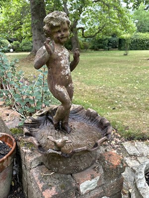 Lot 1279 - Antique cast iron bird bath mounted with a putto standing with a shell, a bird to the rim, 56cm high