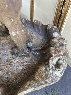 Lot 1279 - Antique cast iron bird bath mounted with a putto standing with a shell, a bird to the rim, 56cm high