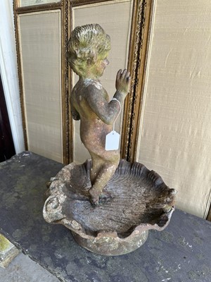Lot 1279 - Antique cast iron bird bath mounted with a putto standing with a shell, a bird to the rim, 56cm high