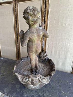Lot 1279 - Antique cast iron bird bath mounted with a putto standing with a shell, a bird to the rim, 56cm high