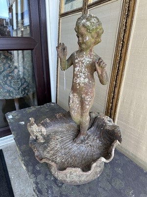 Lot 1279 - Antique cast iron bird bath mounted with a putto standing with a shell, a bird to the rim, 56cm high
