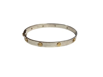 Lot 38 - 9ct white gold hinged bangle with yellow gold screw head design