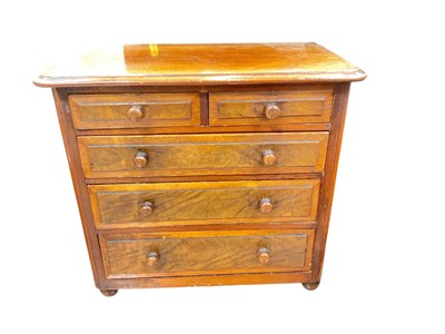 Lot 427 - Mahogany miniature chest of two short and three long draws, filled with various sewing accessories.