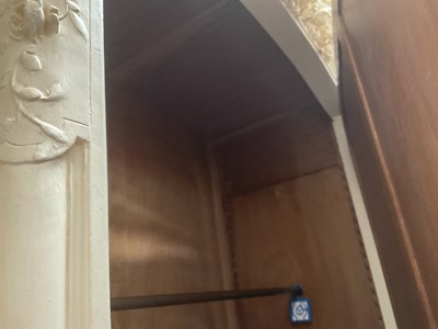 Lot 1353 - An impressive antique rococo revival wardrobe, the central mirrored doors enclosing five flanked by two cupboards, decorated with putti and foliate trailing decoration highlighted in gilt, on sc...
