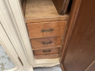 Lot 1353 - An impressive antique rococo revival wardrobe, the central mirrored doors enclosing five flanked by two cupboards, decorated with putti and foliate trailing decoration highlighted in gilt, on sc...