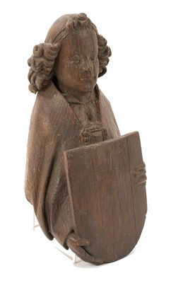 Lot 655 - Ecclesiastical carved oak roof boss, in the form of a saint, holding a shield, possibly mediaeval, 28cm high